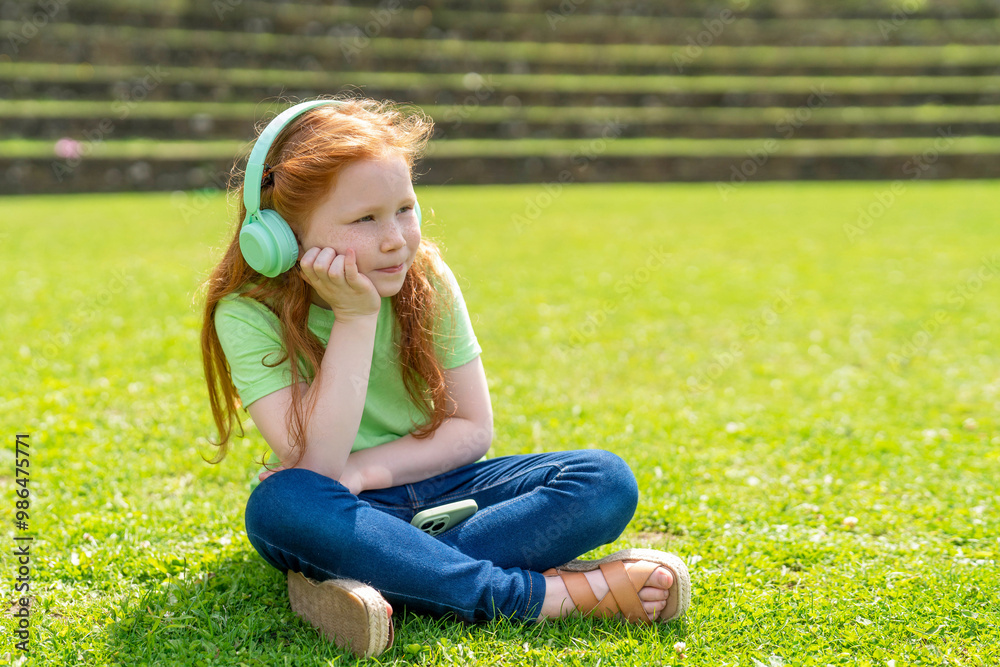 Young Girl Enjoying Moment of Reflection in Sunlit Park While Listening to Music Young Girl Enjoying Moment of Reflection in Sunlit Park While Listening to Music