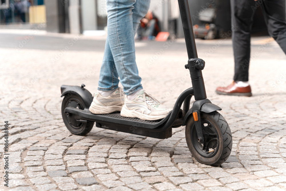 Obraz premium Exploring City on Sleek Electric Scooter Over Cobblestone Streets