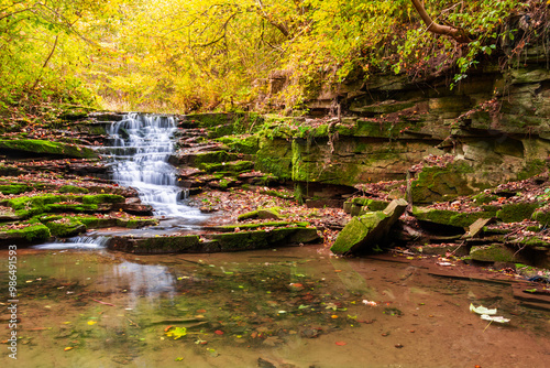 A small cascading waterfall in a mountain stream in the forest. One of the waterfalls of the cascade of Rusiliv waterfalls. Rusyliv, Ternopil Region, Ukraine photo