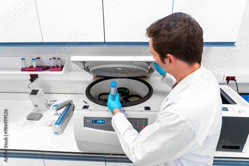 Foto Laboratory technician using refrigerated centrifuge machine in blood bank, Benchtop Centrifuges, Device for laboratory research