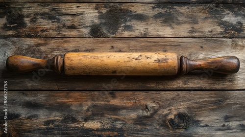 Vintage rolling pin with worn wood, isolated on a rustic wooden table background