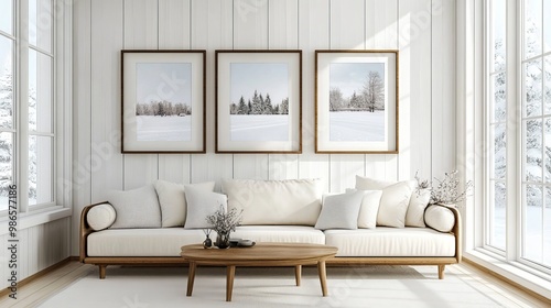 A simple living room with white walls and wood paneling. Picture frames with winter scenes add a touch of warmth.