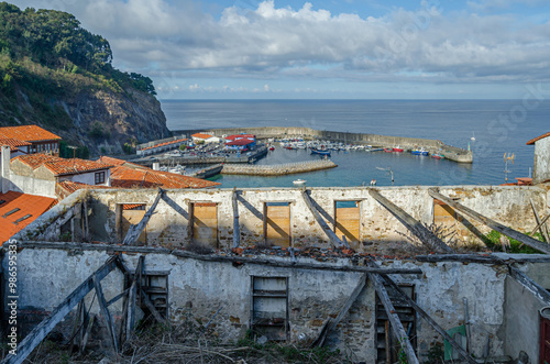 Collapsed building, with the port of Llastres in the background, Spain photo