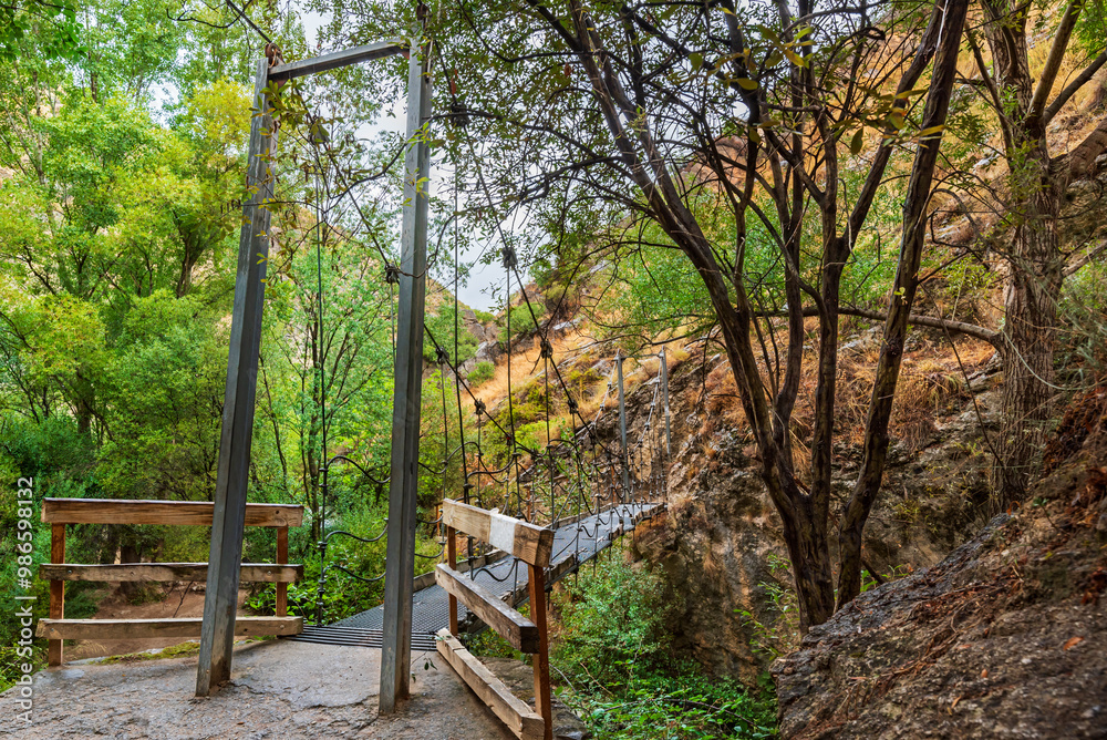 Iron suspension bridge on the Castril River trail, a small bridge for hikers to cross along the Castril River Gorge route, Granada. Iron suspension bridge on the Castril River trail, a small bridge for hikers to cross along the Castril River Gorge route, Granada.