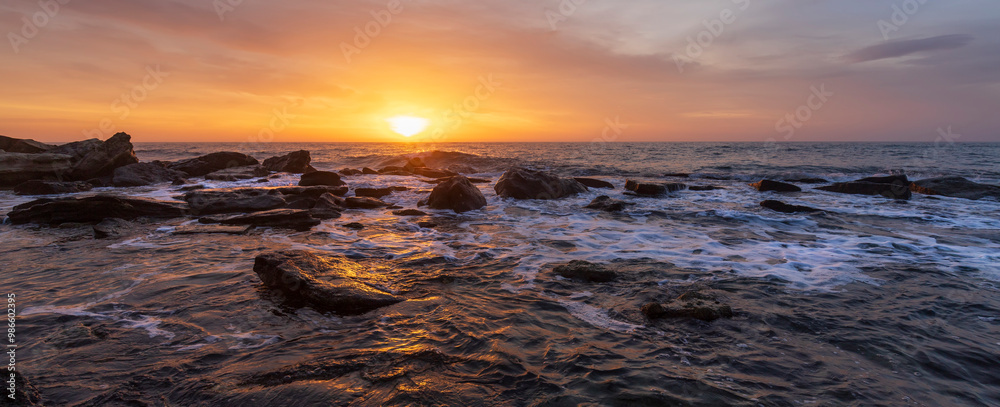 Obraz premium Amazing panoramic view. Sunset over the sea with rocky coast