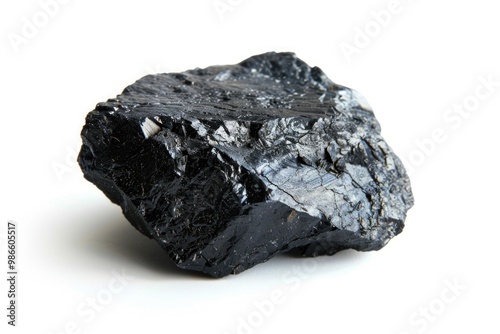 A single piece of coal placed on a clean and white surface