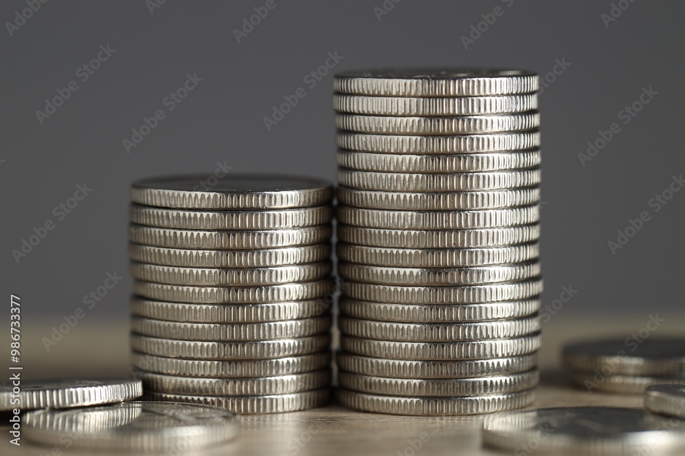 Stacked coins on table against grey background, closeup. Salary concept Stacked coins on table against grey background, closeup. Salary concept