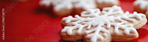 Delicious snowflake-shaped cookie decorated with white icing on a vibrant red background, perfect for winter celebrations.