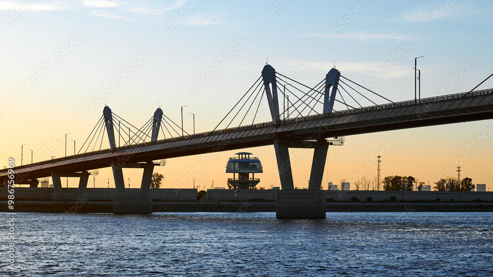 Cross-border bridge on the Amur River between Russia and China. View of the Chinese bank with a spherical observation tower on a summer evening at sunset. Cross-border bridge on the Amur River between Russia and China. View of the Chinese bank with a spherical observation tower on a summer evening at sunset.