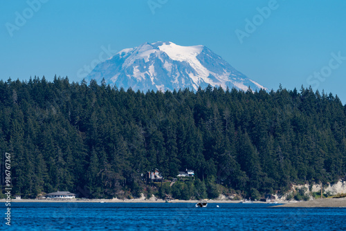 Towering view of snow-capped mount rainier above a pine forest and the puget sound photo