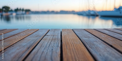 A serene view from a dock with wooden planks leading to a calm water scene at sunset.