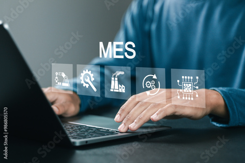 MES manufacturing execution system concept, Manufacturing process operating system that connects the ERP system with the shop floor. Businessman using laptop with MES icons on virtual screen.