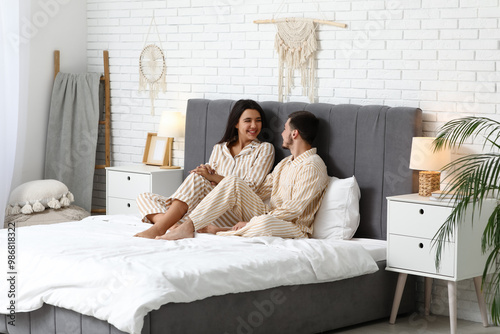 Young couple in pajamas sit...