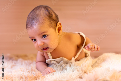 Two-month-old baby boy lying face down on furry rug