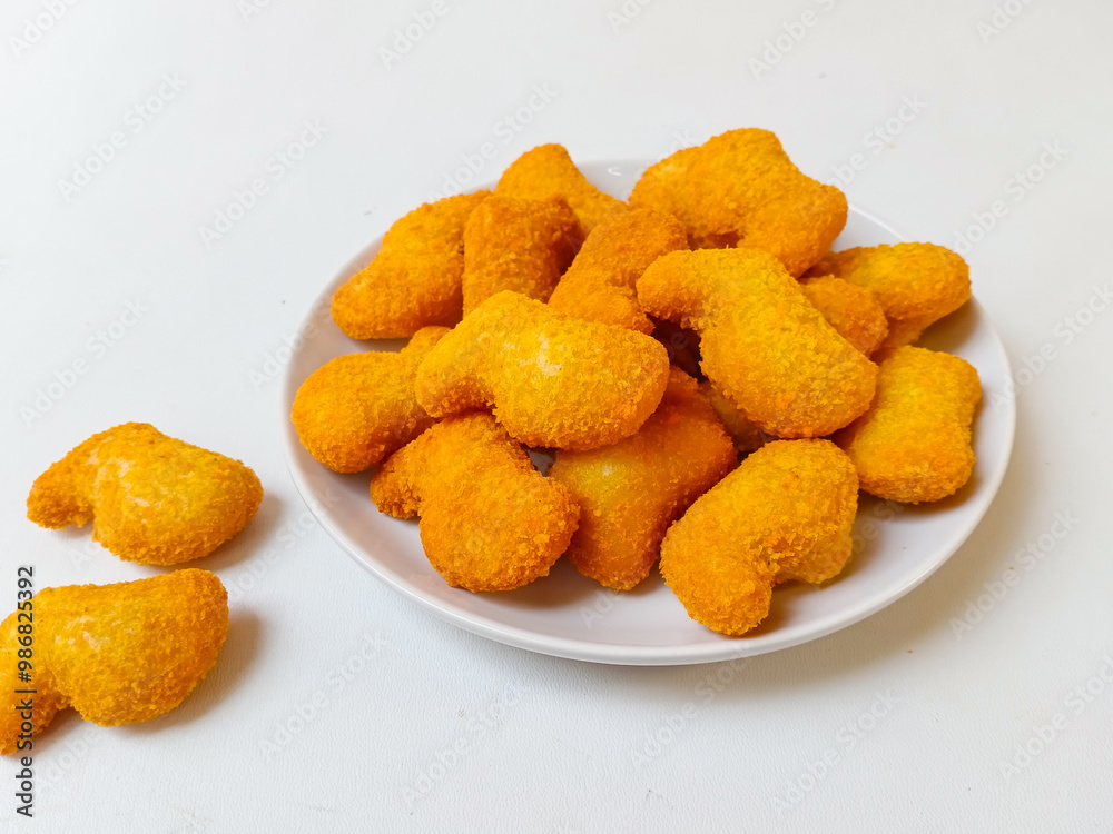 Delicious chicken nuggets in a plate, isolated white background Delicious chicken nuggets in a plate, isolated white background