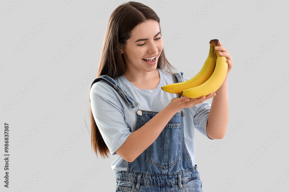 Young woman with bananas on light background Young woman with bananas on light background