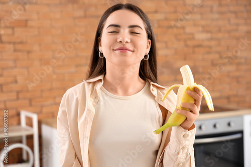 Young woman eating banana i...