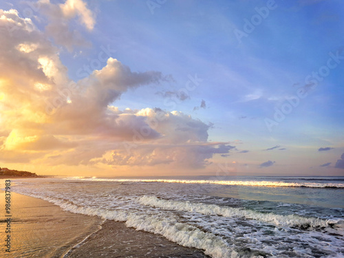 Catching scenic dawn with sunset sky at Bali, Indonesia, with nice waves and low tides, along with summer breeze for a perfect holiday, romantic, and traveling experience. photo