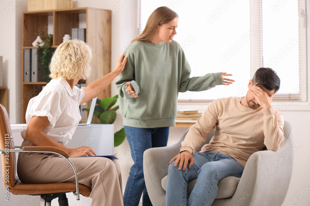 Female psychologist working with angry couple in office Female psychologist working with angry couple in office