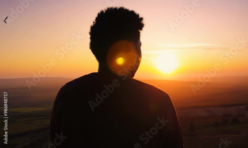 Contemplative Angolan Man by Panoramic Windows at Sunset