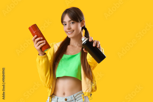 Young girl with spray cans ...