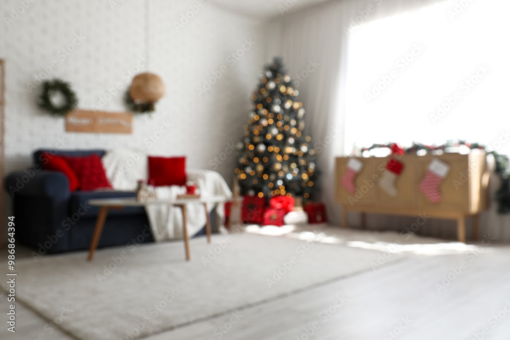 Blurred view of festive living room with grey sofa, glowing lights and Christmas tree Blurred view of festive living room with grey sofa, glowing lights and Christmas tree