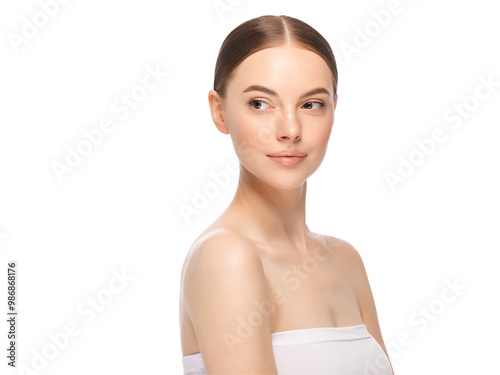 Close-up portrait of young beautiful woman with tied hair after morning beauty routine looking leftwards, shoulder turned to camera photo