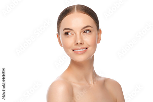 фотографія Young beautiful smiling female pictured with glowing skin and shoulders, looking