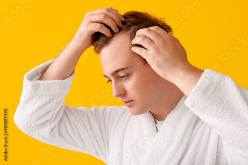 Young redhead man in bathro...