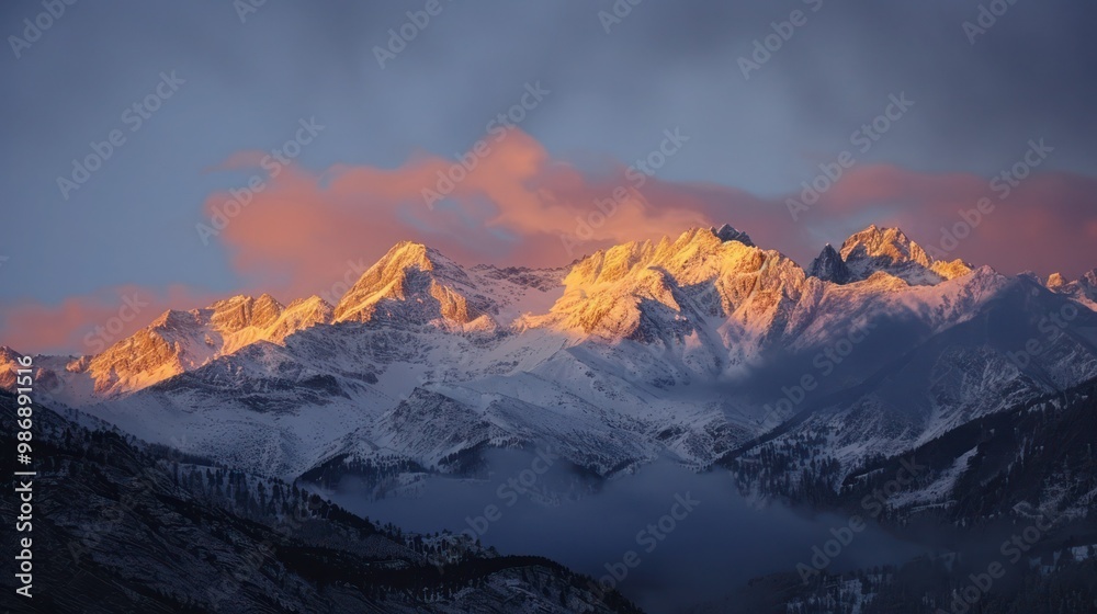 Obraz premium A stunning sunrise over alpine mountains, with the first light of day casting a golden glow on the snowy peaks.