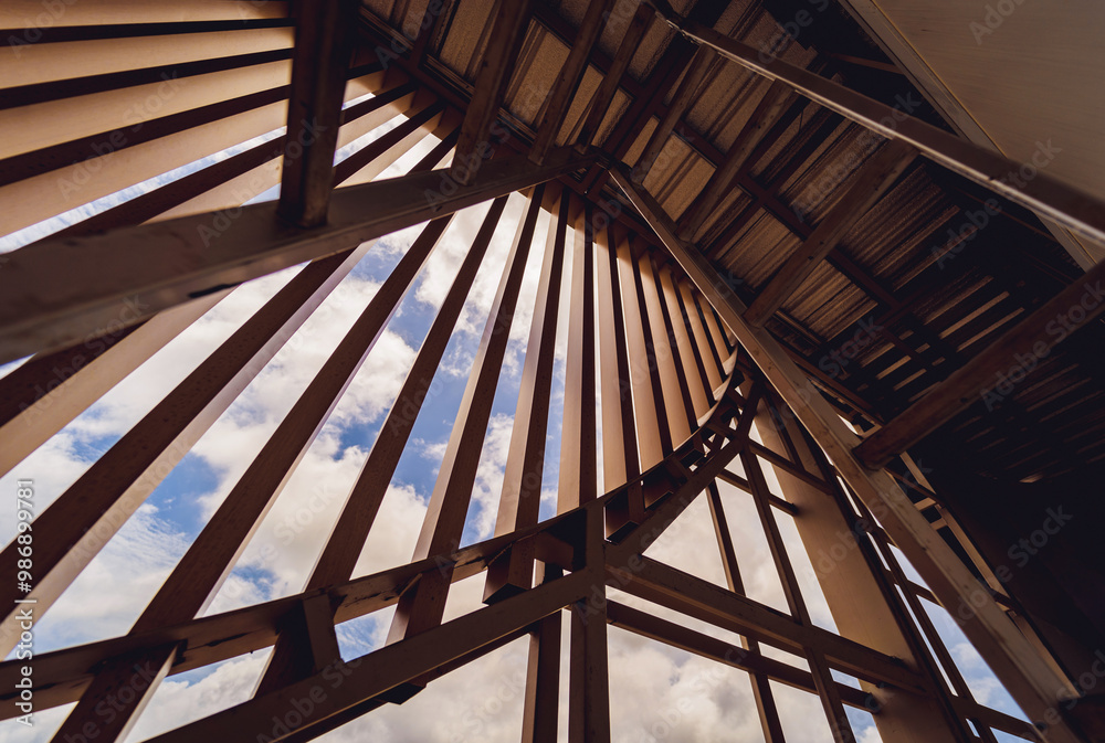 A structure featuring wooden slats on construction site contributing to its architectural style A structure featuring wooden slats on construction site contributing to its architectural style