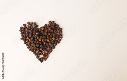 Black pepper placed in the shape of a heart on a white background.
