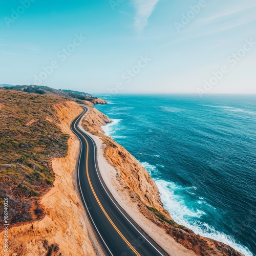 Aerial view of coastal highway beside cliffs and ocean, under a clear blue sky photo