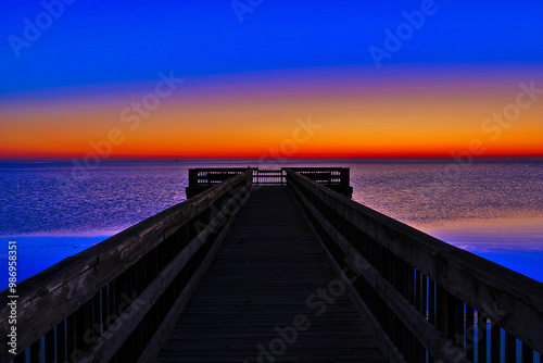 Brilliant orange sunrise over the Gulf of Mexico looking past the fishing dock at Aransas National Wildlife Refuge, outside Austwell, Texas photo