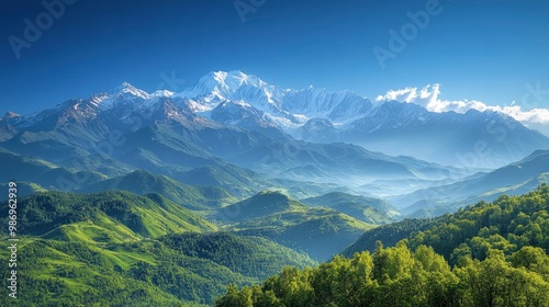 A breathtaking view of a remote, untouched mountain range with snow-capped peaks and rolling green valleys. The clear blue sky and the gentle light of the early morning sun highlight the raw beauty