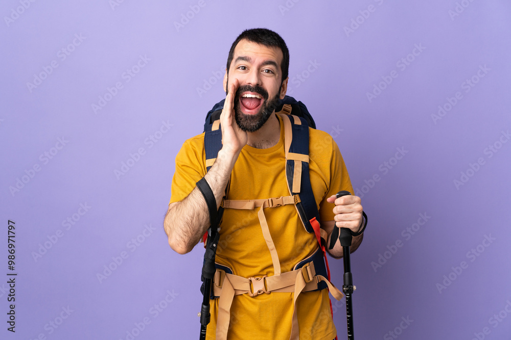 Caucasian handsome man with backpack and trekking poles over isolated background shouting and announcing something Caucasian handsome man with backpack and trekking poles over isolated background shouting and announcing something