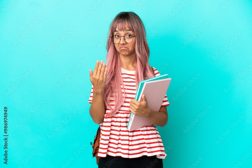 Young student woman with pink hair isolated on blue background inviting to come with hand. Happy that you came Young student woman with pink hair isolated on blue background inviting to come with hand. Happy that you came