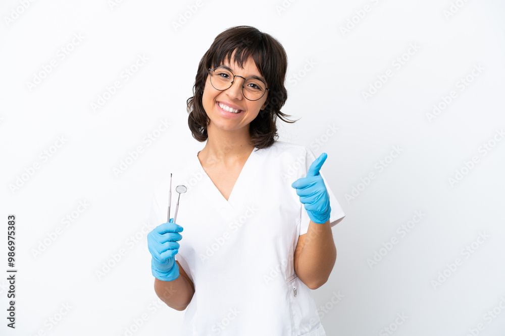 Young woman holding tools isolated on white background with thumbs up because something good has happened Young woman holding tools isolated on white background with thumbs up because something good has happened