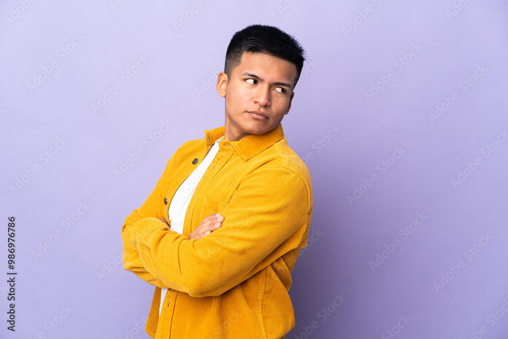 Young Ecuadorian man isolated on purple background keeping the arms crossed Young Ecuadorian man isolated on purple background keeping the arms crossed