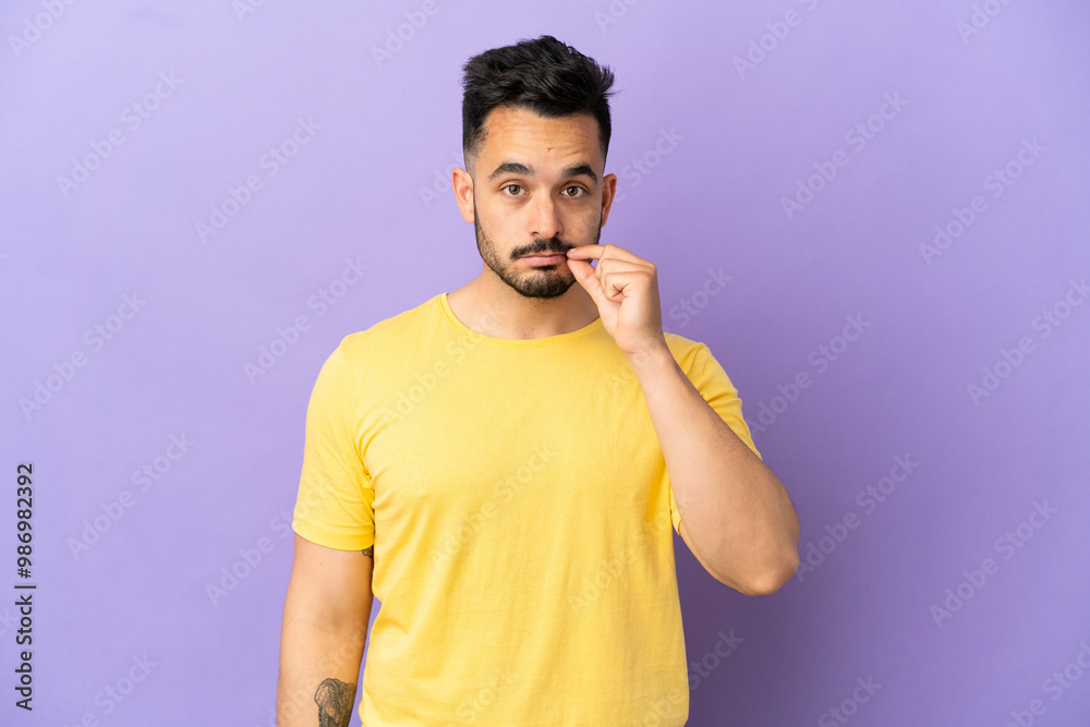 Young caucasian man isolated on purple background showing a sign of silence gesture Young caucasian man isolated on purple background showing a sign of silence gesture