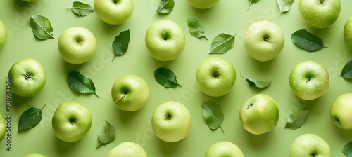 many fresh green apples and green leaves pattern on pastel green background, top view