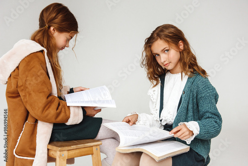 Two schoolgirls with books, first grade.