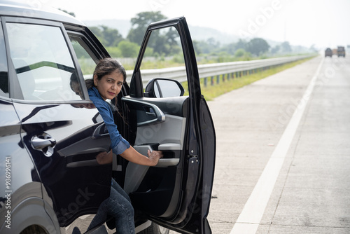 Young woman getting out of the parked car