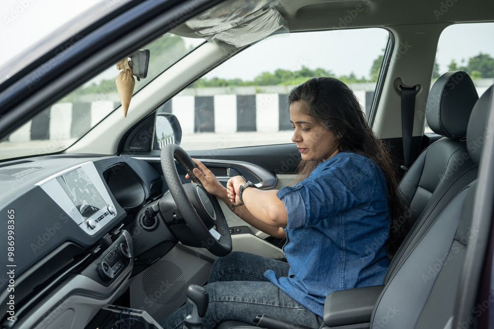 Happy indian woman driving a car in the city. Portrait of smiling female with safety belt traveling in her auto. Happy indian woman driving a car in the city. Portrait of smiling female with safety belt traveling in her auto.