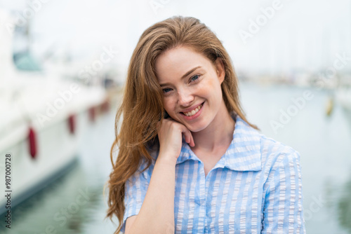 Young redhead woman at outdoors . Portrait