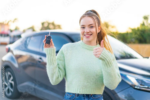 Young pretty girl holding car keys at outdoors pointing up a great idea photo