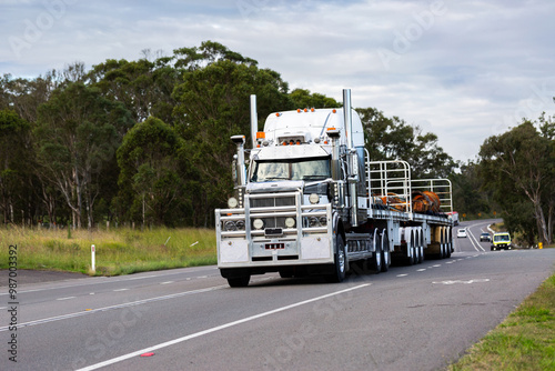 flatbed truck driving down rural road