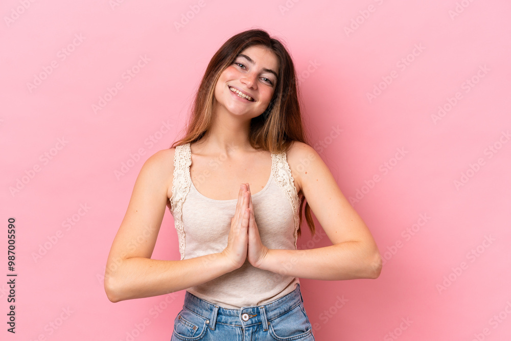 Young caucasian woman isolated on pink background keeps palm together. Person asks for something Young caucasian woman isolated on pink background keeps palm together. Person asks for something