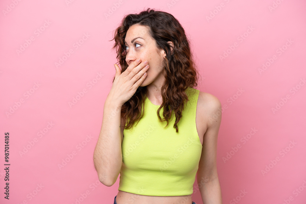 Young caucasian woman isolated on pink background doing surprise gesture while looking to the side Young caucasian woman isolated on pink background doing surprise gesture while looking to the side