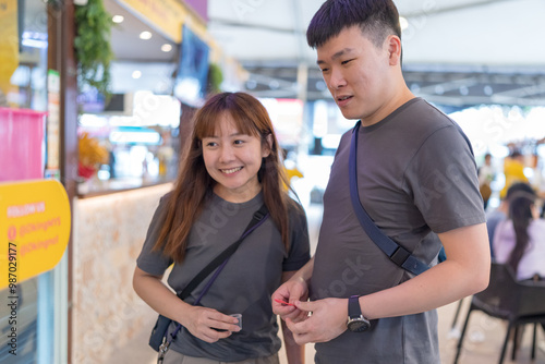 Chinese Malaysian couple in their 30s chatting while eating durian at a famous shop popular with tourists in Kuala Lumpur, Malaysia. photo